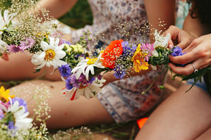 Young hipster women making flower wreaths circle closeup
